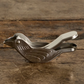 Silver bird-shaped clip on a wooden surface