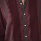 Close-up of a maroon shirt with green and red striped collar and cuffs.