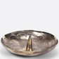Silver dish with a central cone-like object on a white background