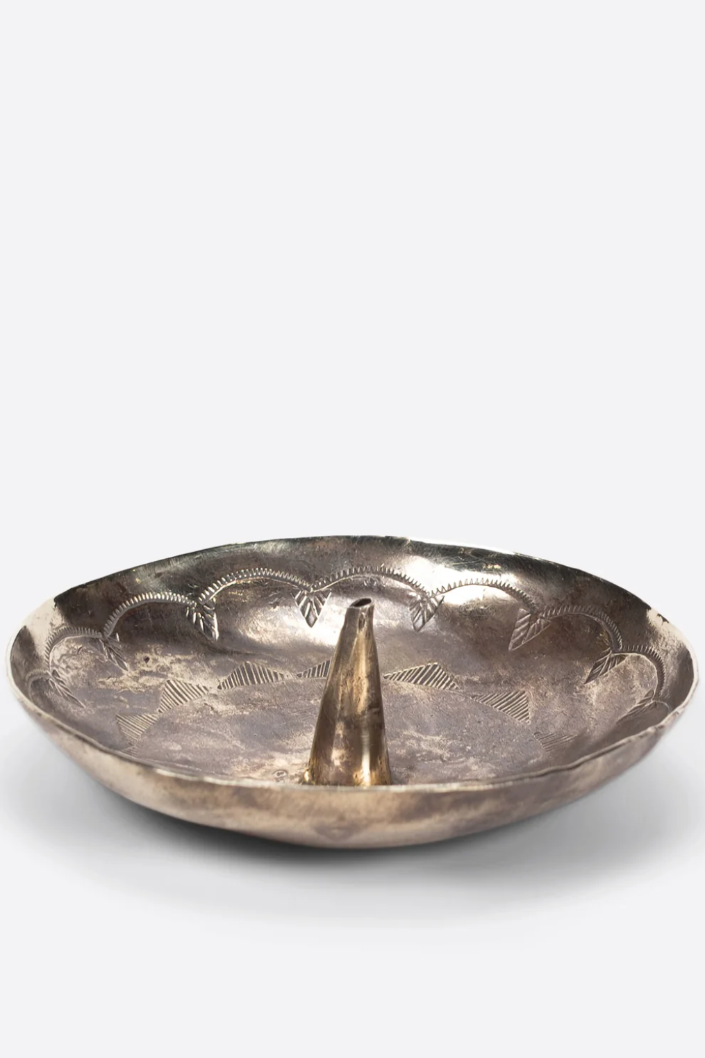 Silver dish with a central cone-like object on a white background