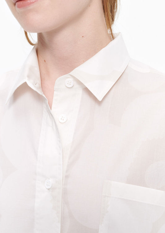 Marimekko Kasvio button-up shirt is made of a light, thin cotton in the beige and off white Unikko (poppy) pattern